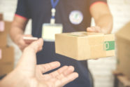 delivery-man-smiling-holding-cardboard-box_1150-8869-d1e06799