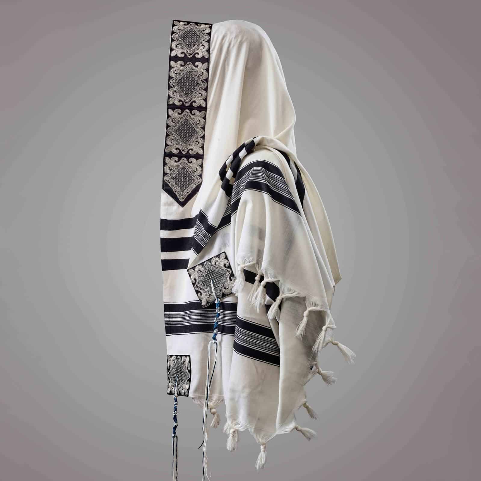 טלית מהודרת עם עיטורי רקמה יוקרתיים מונחת על שולחן