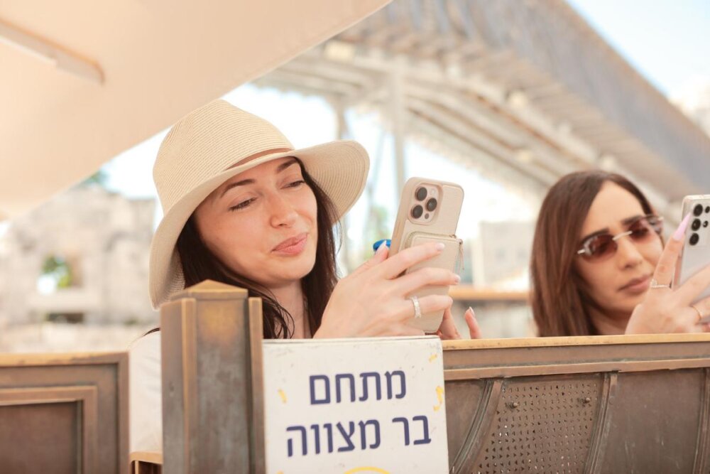 משפחה חוגגת בר מצווה חגיגית עם מתופפים ופייטן ברחבת הכותל